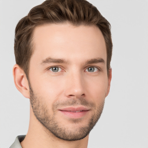 Joyful white young-adult male with short  brown hair and grey eyes