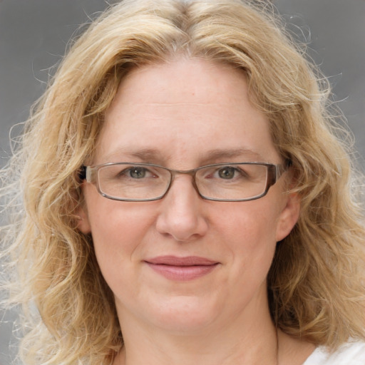 Joyful white adult female with medium  brown hair and blue eyes