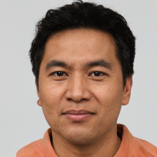 Joyful asian adult male with short  black hair and brown eyes