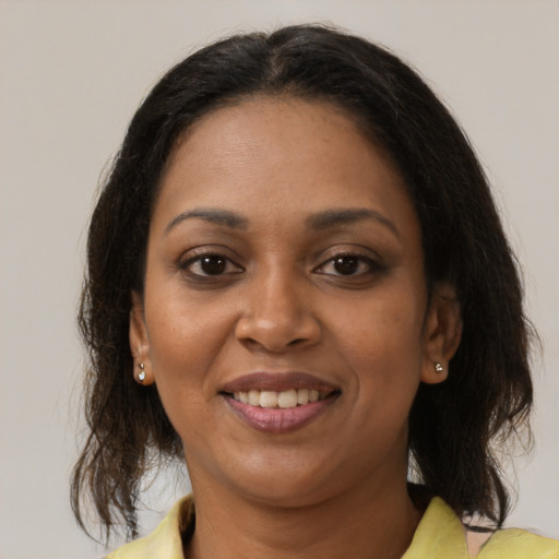 Joyful black adult female with medium  brown hair and brown eyes
