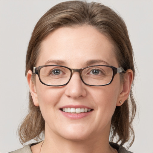 Joyful white young-adult female with medium  brown hair and blue eyes