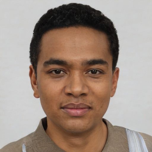 Joyful black young-adult male with short  black hair and brown eyes