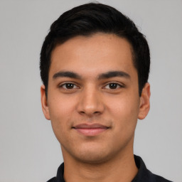 Joyful latino young-adult male with short  black hair and brown eyes