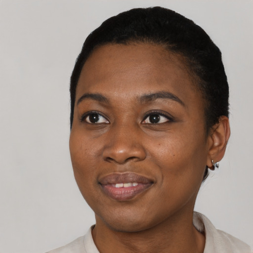 Joyful black young-adult female with short  black hair and brown eyes