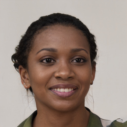 Joyful black young-adult female with long  black hair and brown eyes