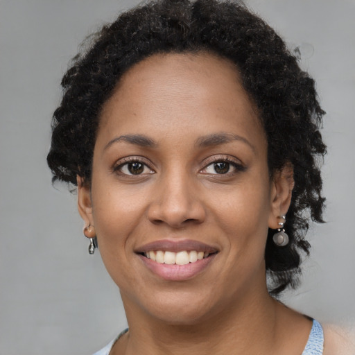 Joyful black young-adult female with short  black hair and brown eyes