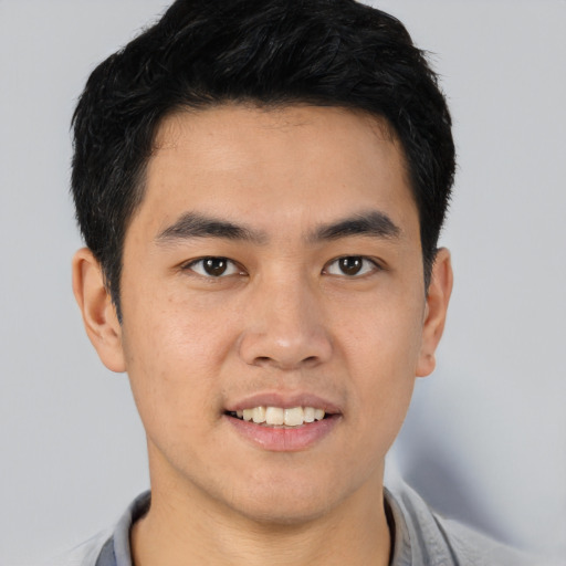 Joyful asian young-adult male with short  brown hair and brown eyes