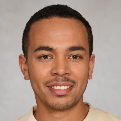 Joyful latino young-adult male with short  brown hair and brown eyes