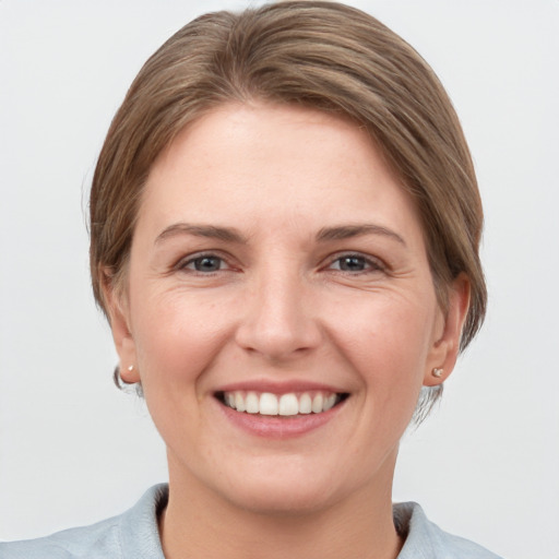 Joyful white young-adult female with short  brown hair and grey eyes