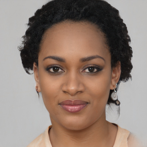 Joyful black young-adult female with long  black hair and brown eyes