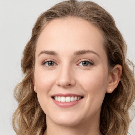 Joyful white young-adult female with long  brown hair and green eyes