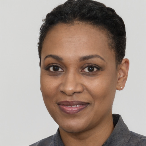 Joyful black adult female with short  black hair and brown eyes