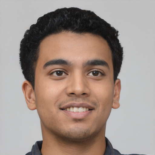 Joyful latino young-adult male with short  black hair and brown eyes