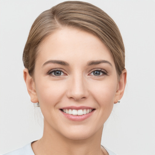 Joyful white young-adult female with medium  brown hair and grey eyes