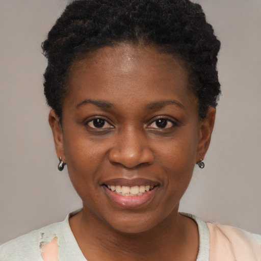 Joyful black young-adult female with short  black hair and brown eyes