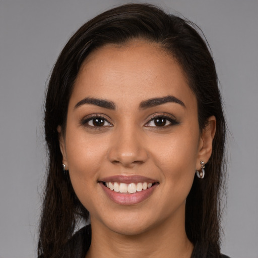 Joyful latino young-adult female with long  brown hair and brown eyes