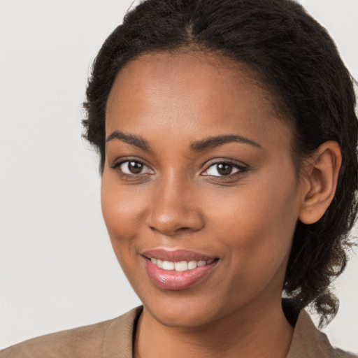 Joyful black young-adult female with medium  brown hair and brown eyes