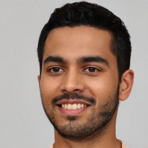 Joyful latino young-adult male with short  black hair and brown eyes