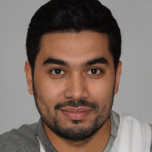 Joyful latino young-adult male with short  black hair and brown eyes