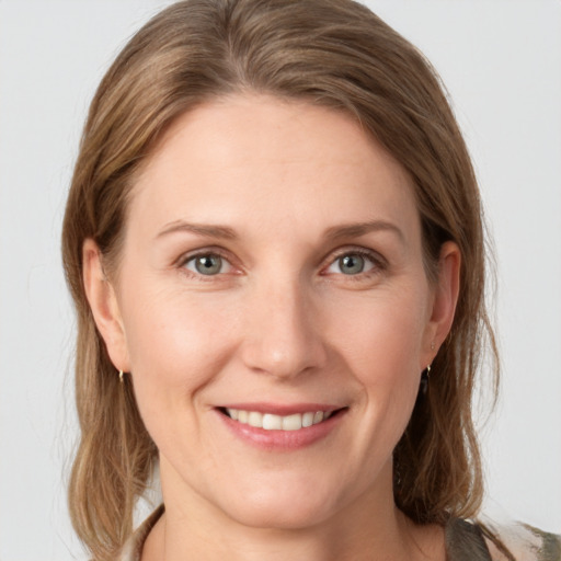 Joyful white young-adult female with medium  brown hair and grey eyes