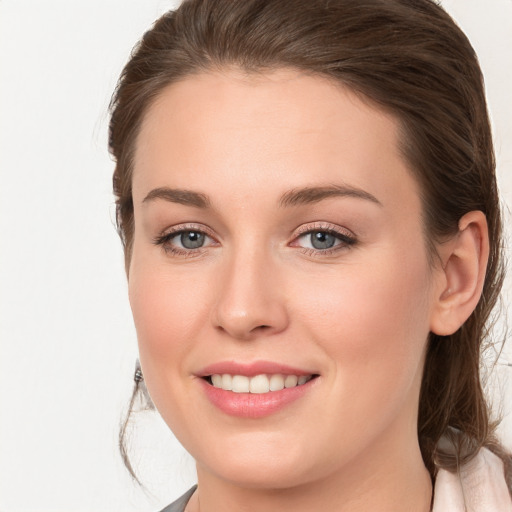 Joyful white young-adult female with long  brown hair and grey eyes