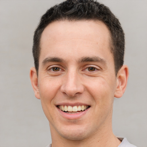 Joyful white young-adult male with short  brown hair and brown eyes