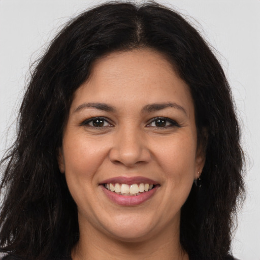 Joyful latino young-adult female with long  brown hair and brown eyes