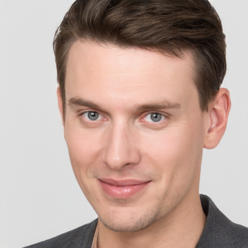 Joyful white young-adult male with short  brown hair and grey eyes