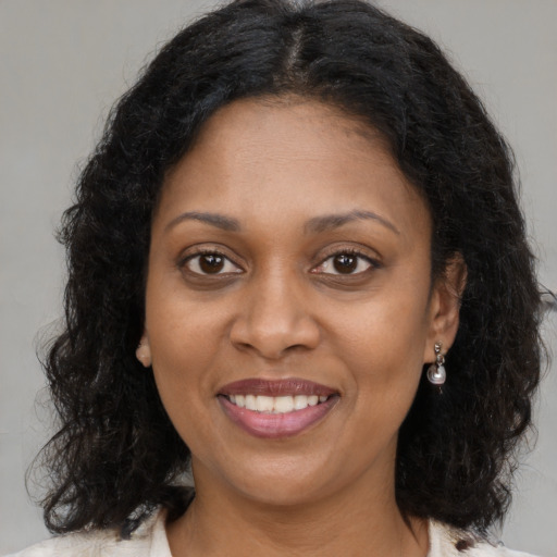 Joyful black young-adult female with medium  brown hair and brown eyes
