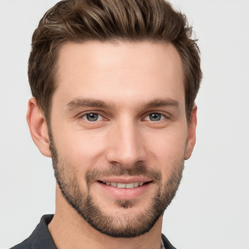 Joyful white young-adult male with short  brown hair and grey eyes