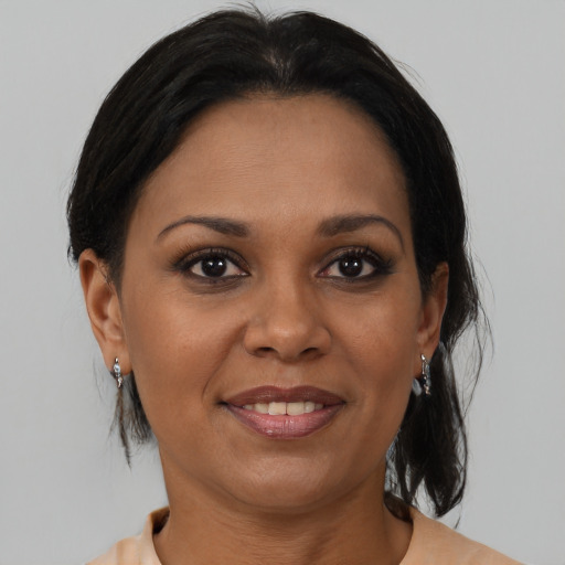 Joyful black adult female with medium  brown hair and brown eyes