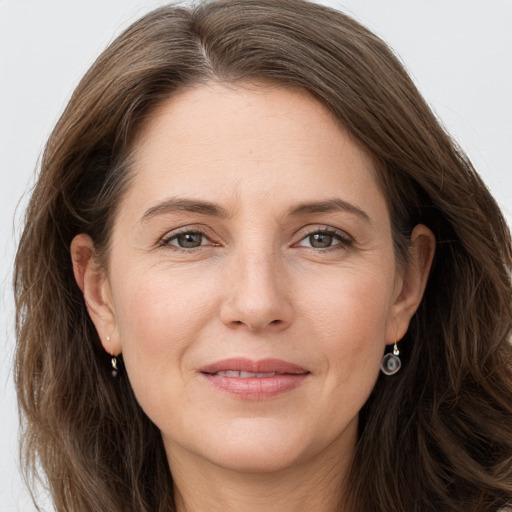 Joyful white adult female with long  brown hair and grey eyes