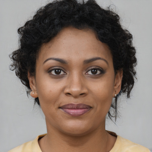 Joyful black young-adult female with short  brown hair and brown eyes