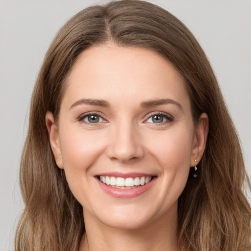 Joyful white young-adult female with long  brown hair and grey eyes