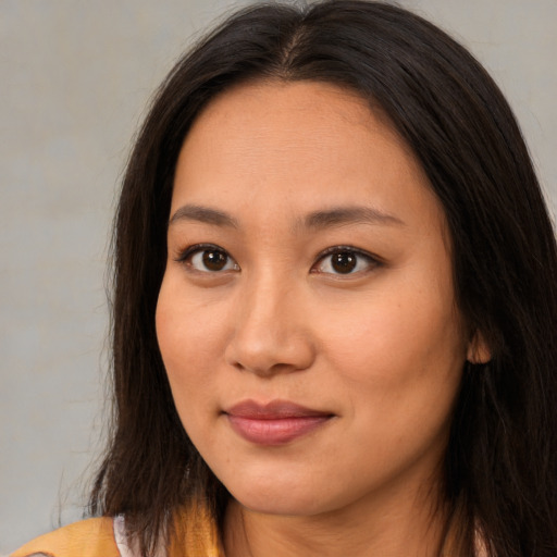 Joyful asian young-adult female with long  brown hair and brown eyes