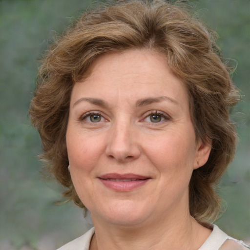 Joyful white adult female with medium  brown hair and green eyes