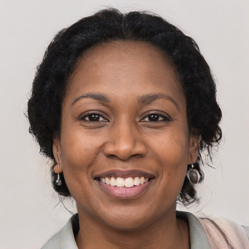 Joyful black adult female with medium  brown hair and brown eyes