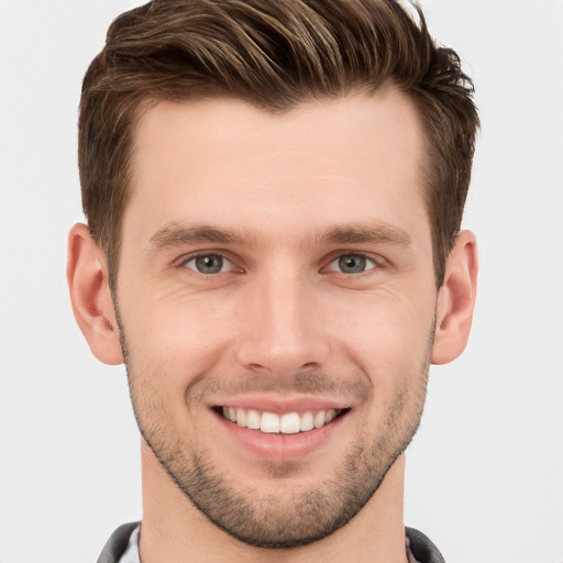 Joyful white young-adult male with short  brown hair and grey eyes