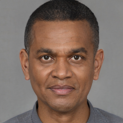 Joyful black adult male with short  black hair and brown eyes