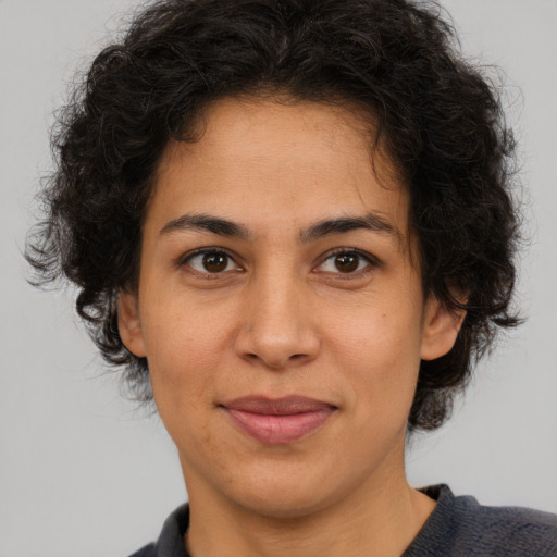 Joyful latino adult female with medium  brown hair and brown eyes