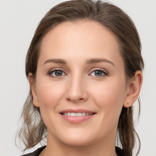 Joyful white young-adult female with medium  brown hair and grey eyes