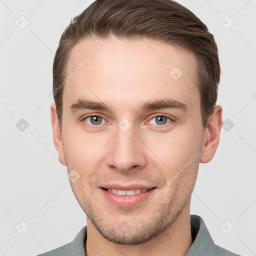 Joyful white young-adult male with short  brown hair and grey eyes