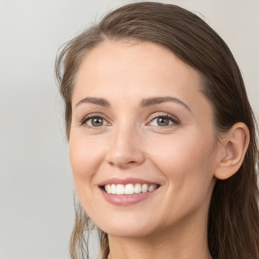 Joyful white young-adult female with long  brown hair and grey eyes