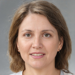 Joyful white adult female with medium  brown hair and grey eyes