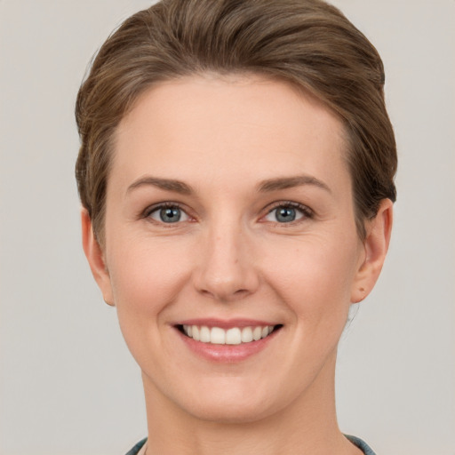 Joyful white young-adult female with short  brown hair and grey eyes