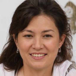 Joyful white adult female with medium  brown hair and brown eyes