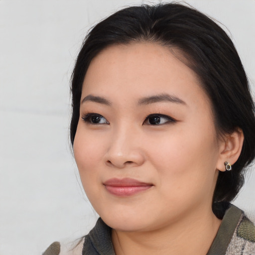Joyful asian young-adult female with medium  black hair and brown eyes