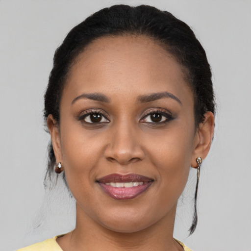 Joyful black young-adult female with long  black hair and brown eyes