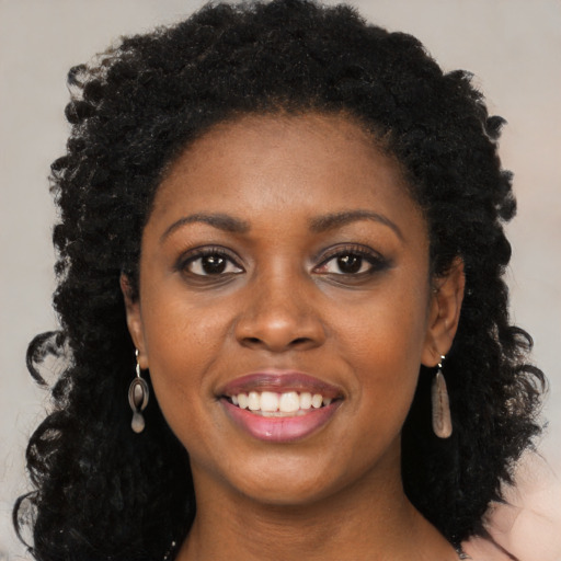 Joyful black young-adult female with long  black hair and brown eyes