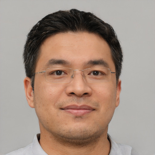 Joyful asian adult male with short  brown hair and brown eyes